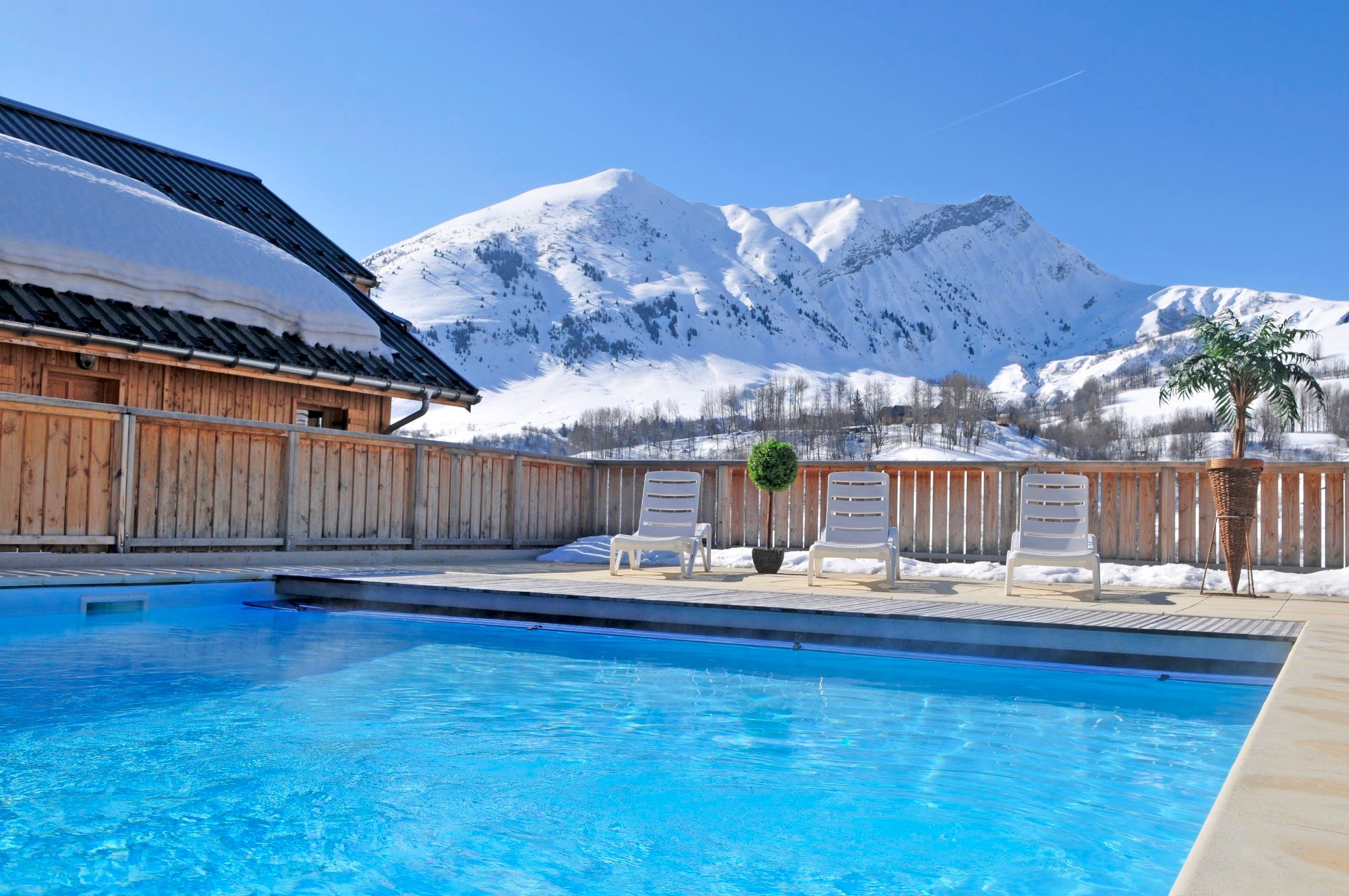 image Heated outdoor pool, empty loungers, mountain view, winter