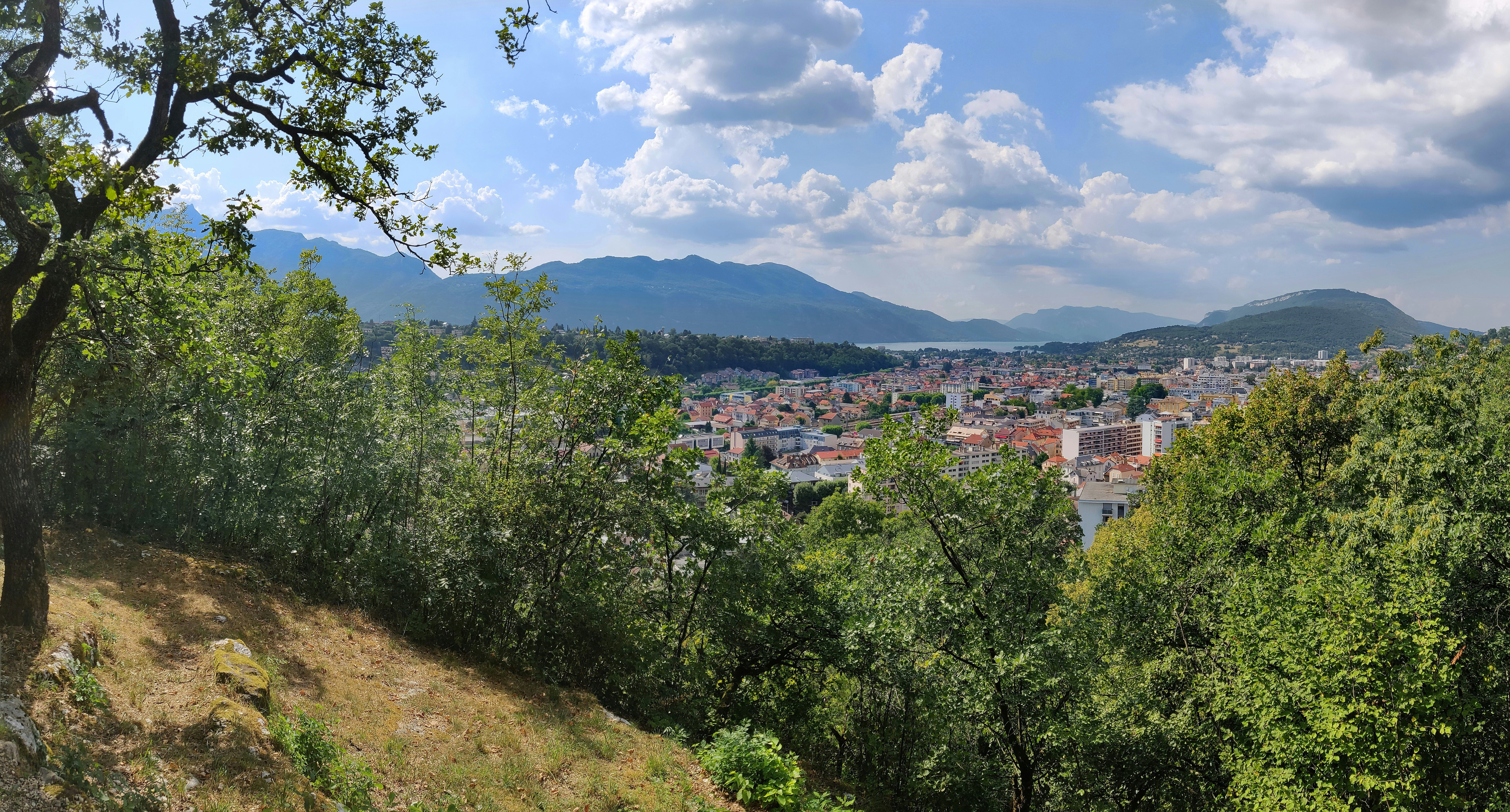 image Panoramic view of a town surrounded by hills and trees.