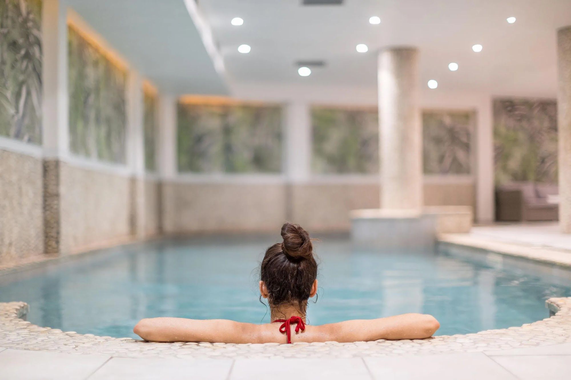 image Person relaxing beside a pool in the spa area.
