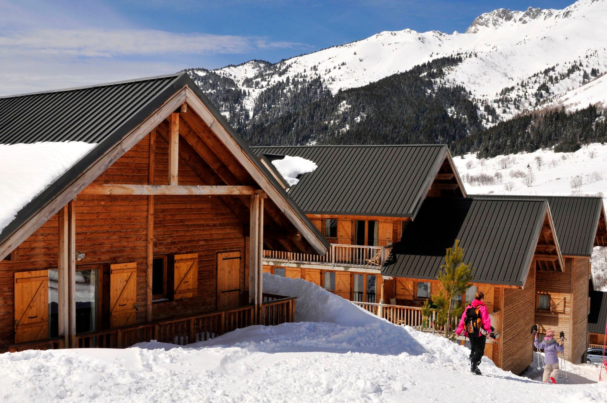image Wooden cabins with snow on the roof and pine trees nearby