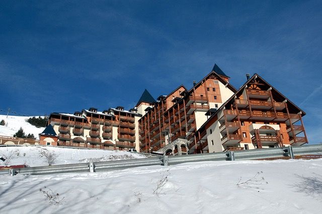 image Clear blue skies above the building and snowy hillside.
