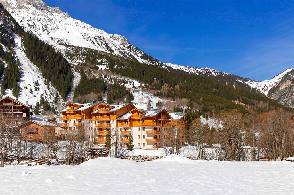 image The chalet framed by mountain scenery, with the village spread out below.