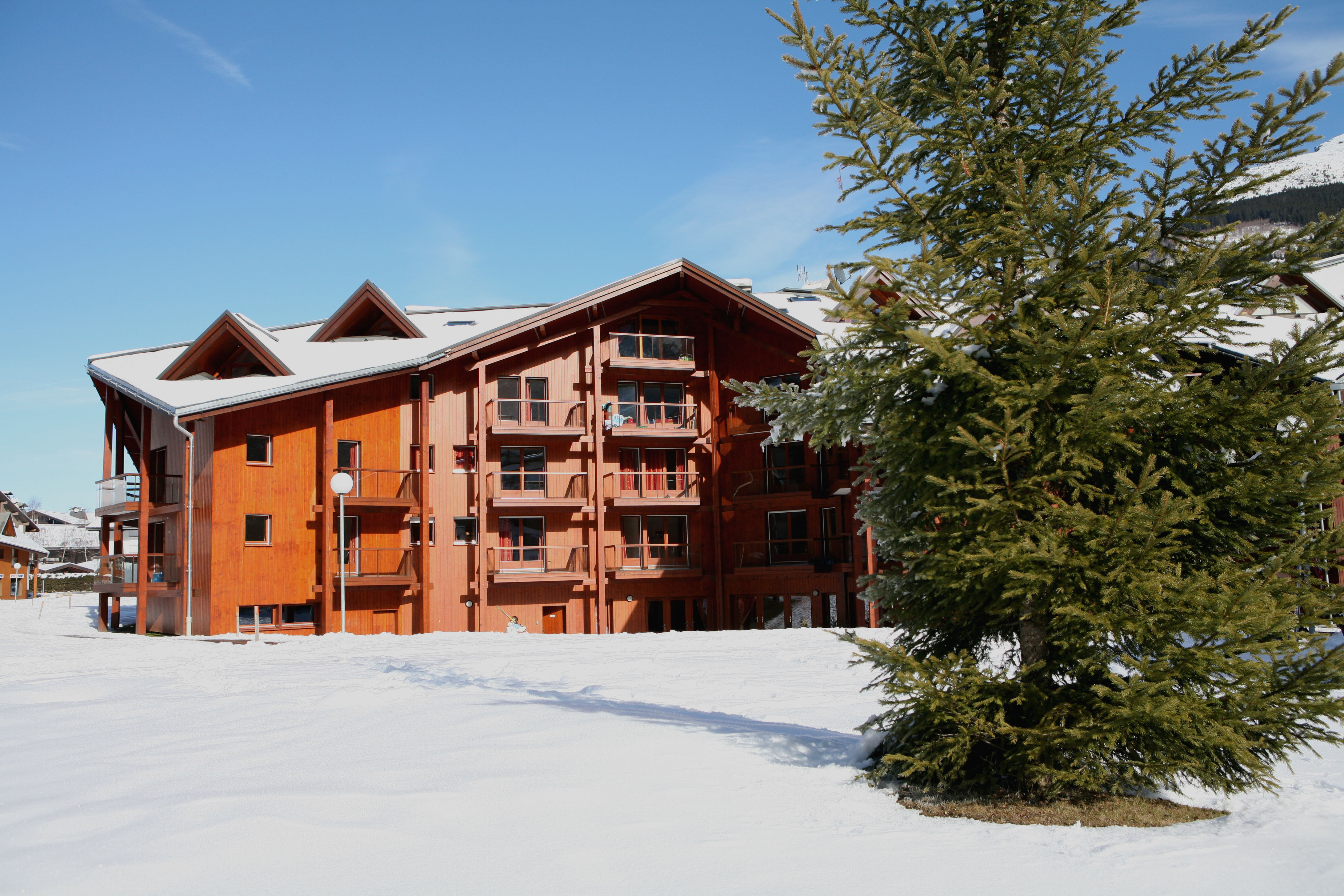 image Timber balconies and a dusting of snow, framed against the Alps.