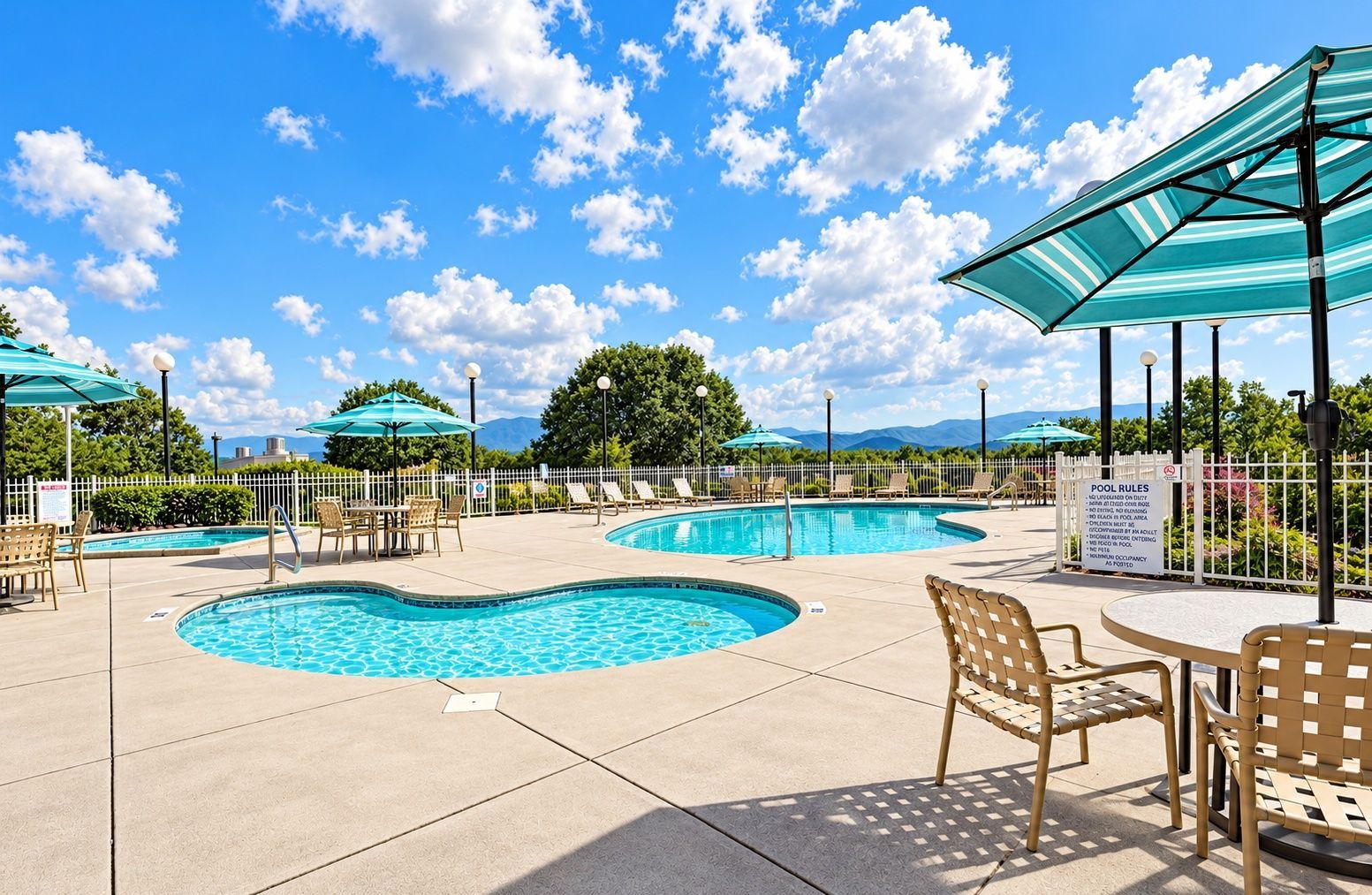 image Outdoor pool deck with tables, umbrellas, and mountain view