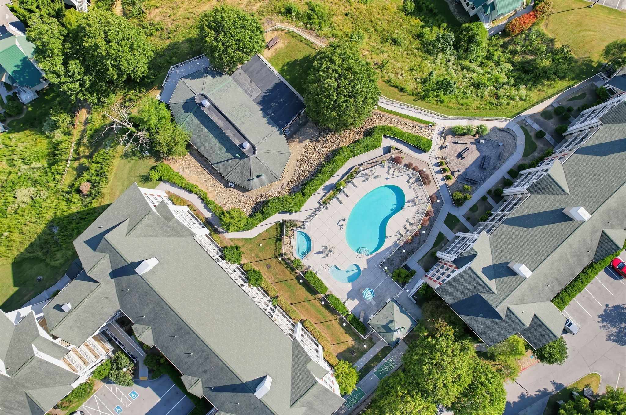 image Aerial view of buildings and swimming pool surrounded by greenery