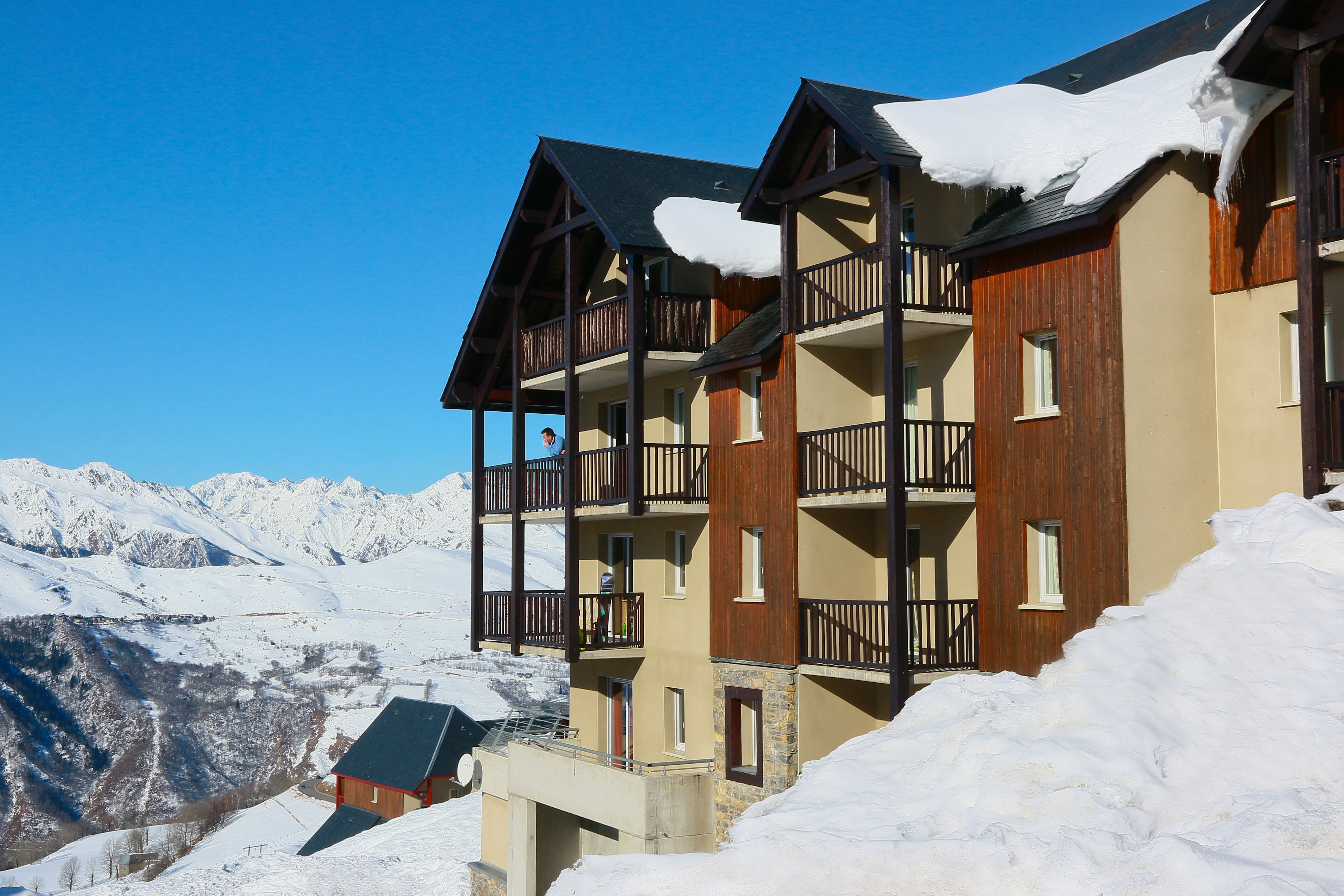 image Multi-level building with balconies overlooking snow-covered landscape and mountains