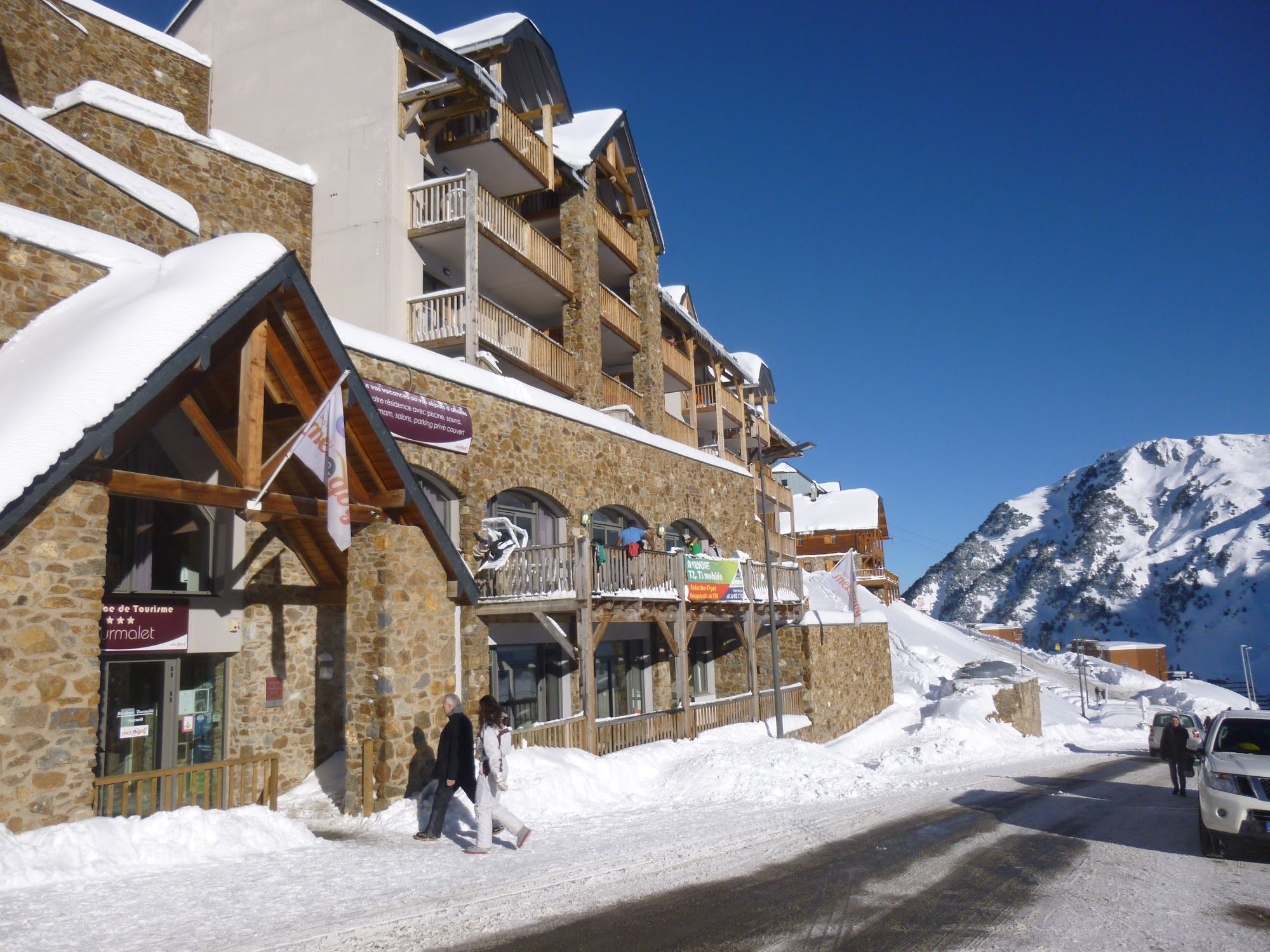 image Pathway near buildings and snowy mountains, sunny weather