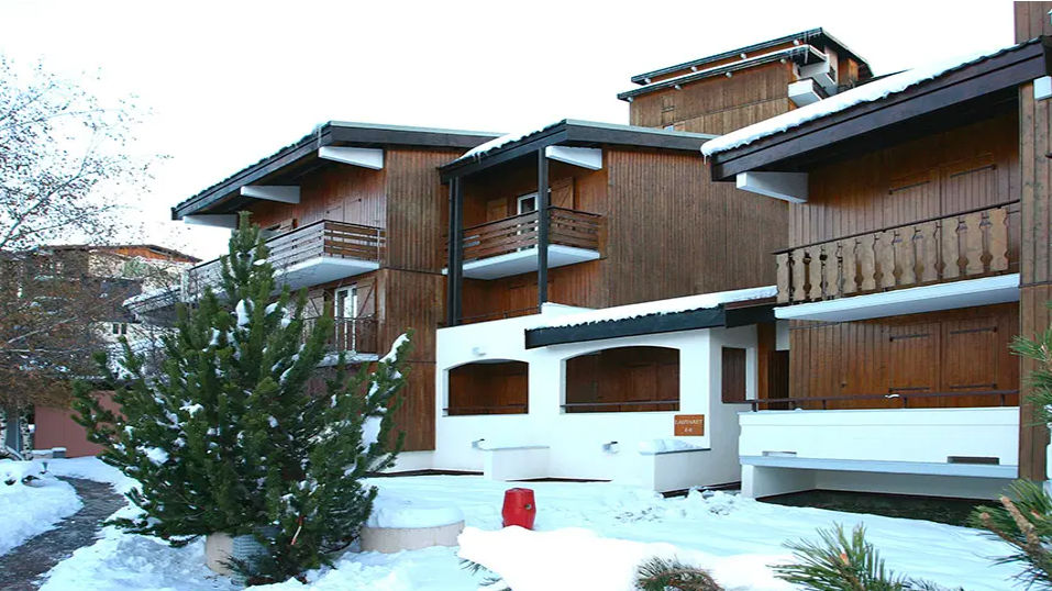 image Snow settles on the timber balconies, framing a calm winter hideaway beneath clear alpine skies.